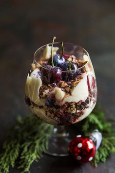 a dessert in a glass with cherries on top