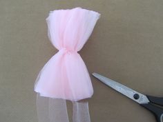 a pair of scissors sitting next to a piece of tulle on top of a table