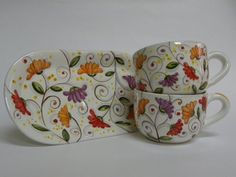 three coffee cups and saucers decorated with flowers