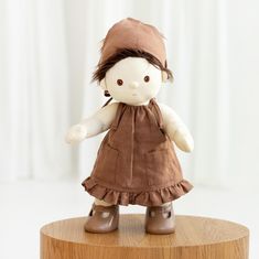 a doll is sitting on top of a wooden table