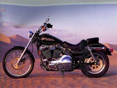 a black motorcycle parked on top of a dirt field