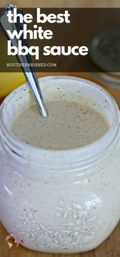 a jar filled with white sauce sitting on top of a wooden table next to a banana