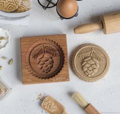 a wooden stamp with grapes and leaves on it next to some other items that include rolling pins