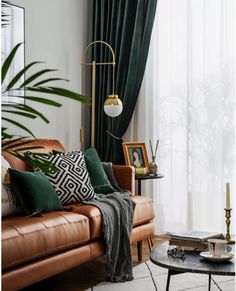 a living room with leather couches and green drapes on the windowsills