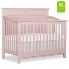 a pink crib with white sheets on it