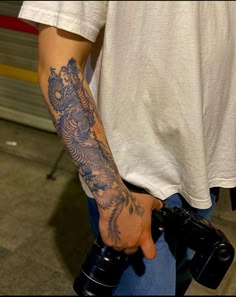 a man with a tattoo on his arm holding a camera