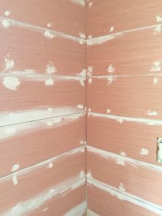 the wall is painted pink and has white paint on it