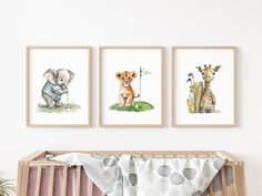 three pictures of animals are hanging on the wall above a crib in a baby's room