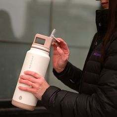 a woman holding a water bottle in her hands