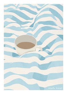 a cup of coffee sitting on top of a blue and white wave pattern paper covered ground