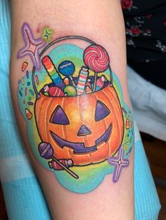 a halloween pumpkin with candy and candies in it's basket on the arm