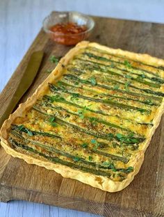 asparagus and cheese quiche on a wooden cutting board