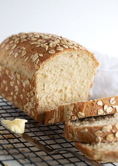 a loaf of bread sitting on top of a cooling rack next to a piece of butter