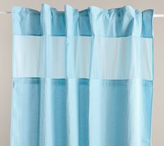 a shower curtain with blue and white stripes on it's side, hanging from a hook