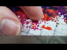 someone is stitching on the side of a cross - stitch pattern with their fingers