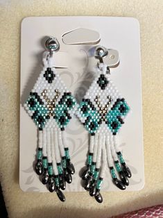 a pair of beaded earrings with black and white beads