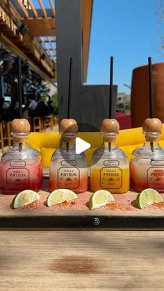 four bottles of liquid sitting on top of a wooden tray