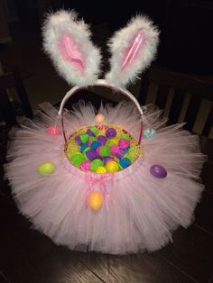 a pink tutu with bunny ears and candy in the center is sitting on a table