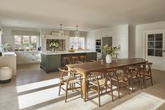 a dining room table and chairs in front of a kitchen with an island countertop