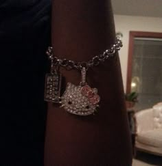 a hello kitty charm on a woman's arm