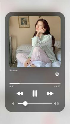 a woman sitting on top of a bed next to an mp3 player