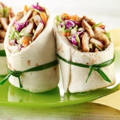 two wraps filled with veggies on top of a green plate