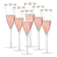 six champagne glasses with pink liquid in them