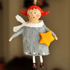 a ceramic ornament with a red haired girl holding a star in her hand