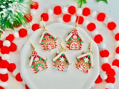 four gingerbread christmas cookies on a white plate with red and green decorations around them