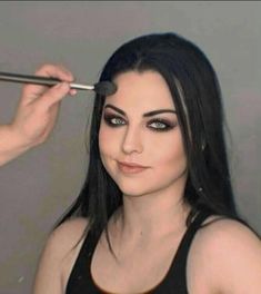 a woman getting her make up done with makeup brush