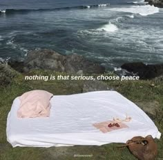 there is a white blanket on the ground by the ocean with an inspirational quote about nothing is that serious, choose peace