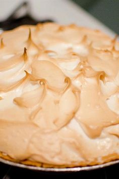 a pie sitting on top of a stove covered in frosting