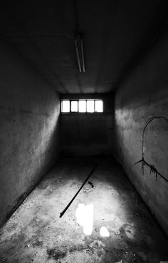 an empty room with three windows and bars on the floor in black and white photo