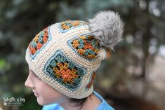 a child wearing a crocheted hat with a pom - pom