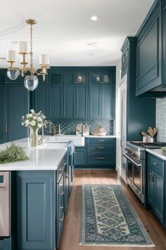 a large kitchen with blue cabinets and white counter tops, along with a rug on the floor