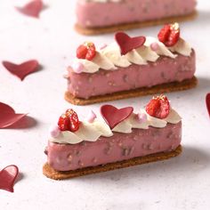 three small pieces of cake with hearts on top and one slice has strawberries in it