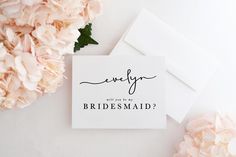 a card with the word bridesmaid written on it next to pink carnations