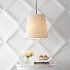 a lamp that is sitting on top of a table next to a vase with flowers