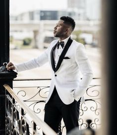 a man in a tuxedo leaning against a railing