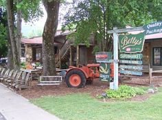 an old tractor is parked in front of a building with a sign that says butters on it