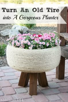 an old tire turned into a gorgeous planter with rope and flowers in the center