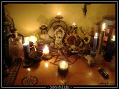 a table topped with candles and other items on top of a wooden table next to a wall