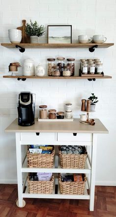 a white table topped with shelves filled with coffee cups and other kitchen items on top of it