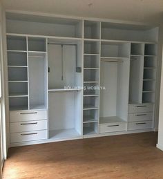 an empty room with white shelves and drawers