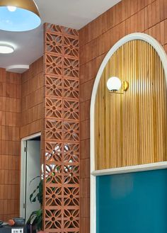 an arched window in the corner of a room with blue walls and wood paneling