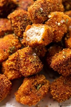 some fried food on a white plate with seasoning sprinkled around the edges