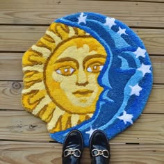 a pair of black shoes sitting on top of a rug with a sun and moon design