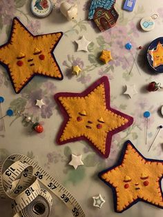 three star shaped patches sitting on top of a table next to a measuring tape and buttons