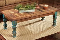 a wooden table sitting on top of a rug in front of a couch and coffee table