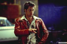 a man in a red leather jacket pointing at something